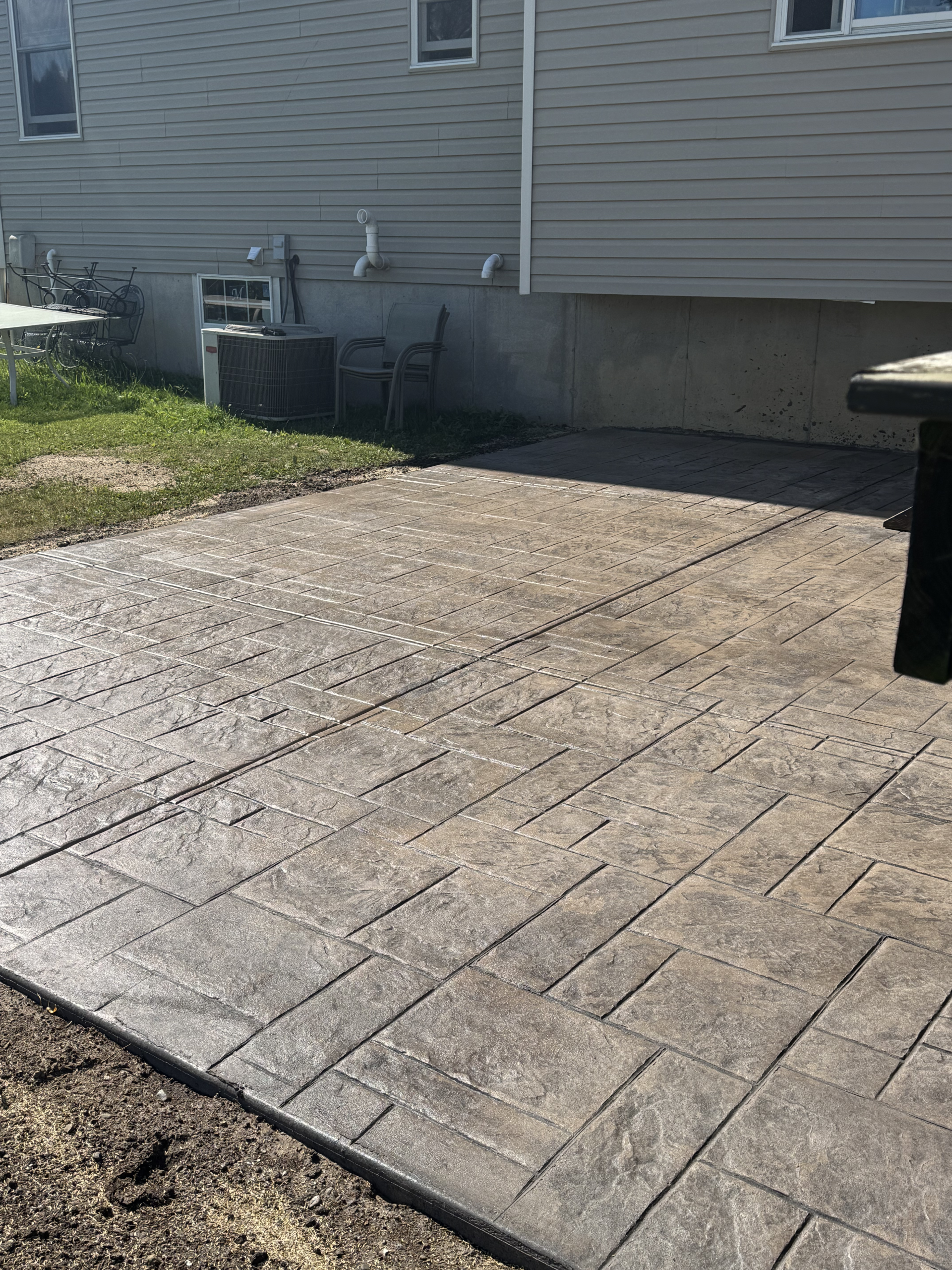 Stamped concrete patio transformation replacing an old wood deck in Central New York